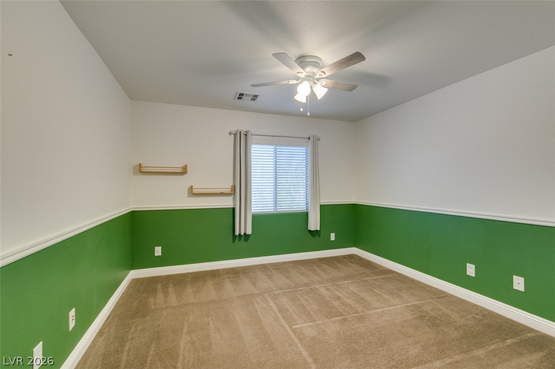 8909 Houston Ridge Avenue Las Vegas, NV 89178 - Photo 31 of 45 A quiet bedroom with a ceiling fan, plush carpeting, and sun-filtering window blinds for tranquil repose.