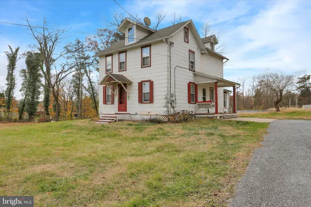a front view of house with yard and trees in the background