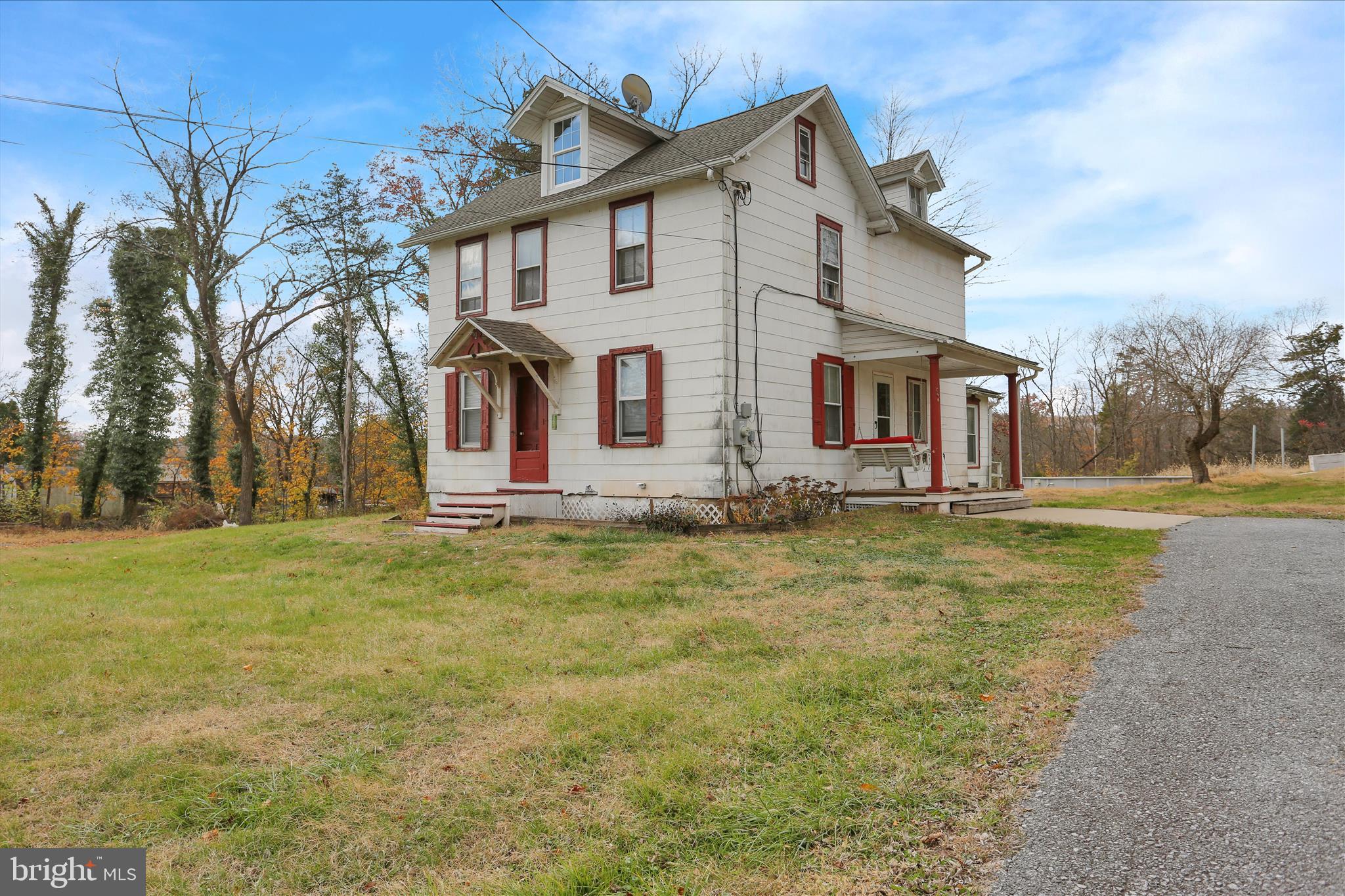 a front view of house with yard and trees in the background