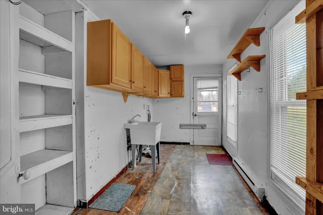 a view of a kitchen with wooden floor and cabinets