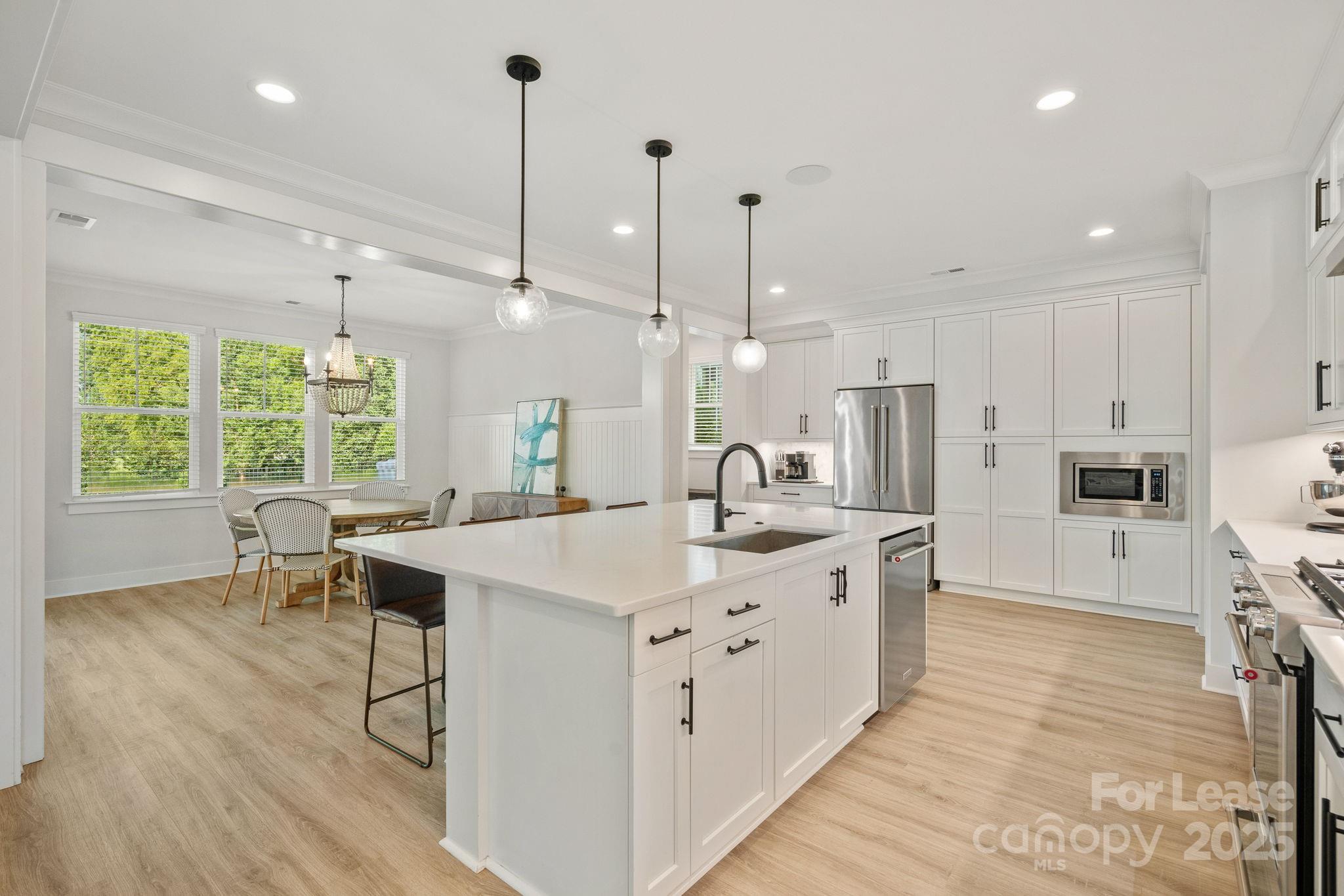 12012 Huntson Reserve Road Huntersville, NC 28078 - Photo 10 of 36 a kitchen with stainless steel appliances kitchen island a white cabinets and wooden floor