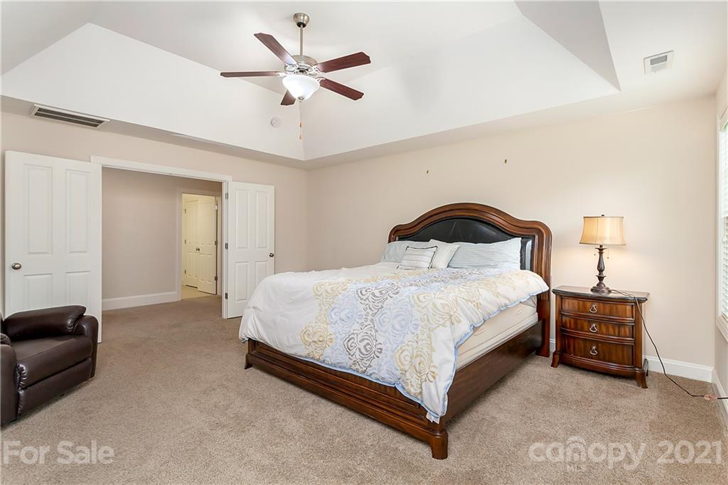 2522 Walker Road Matthews, NC 28105 - Photo 17 of 37 a spacious bedroom with a bed and a chandelier