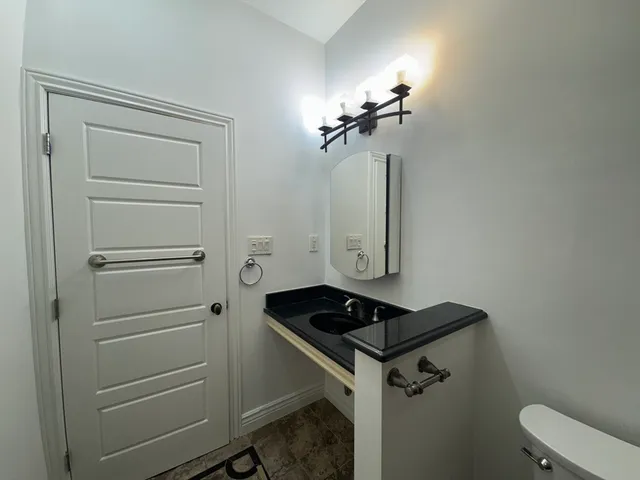a bathroom with a sink a toilet and a mirror