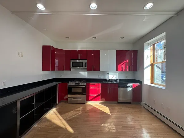 a kitchen with stainless steel appliances granite countertop a stove a sink and a microwave