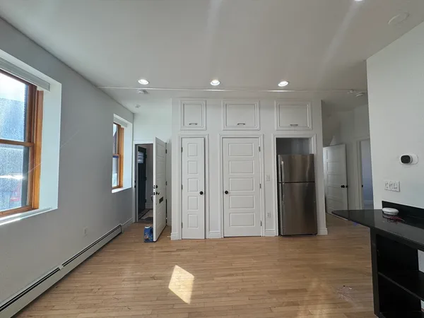 a view of a kitchen with a refrigerator and wooden floor