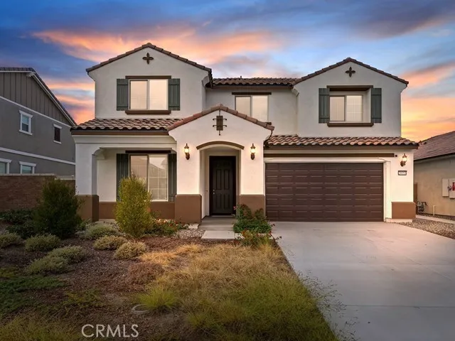 a front view of a house with yard and parking