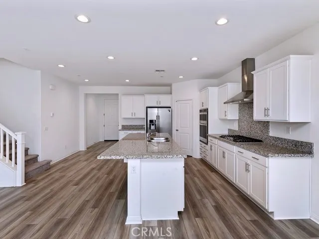 a kitchen with stainless steel appliances granite countertop a sink stove and cabinets