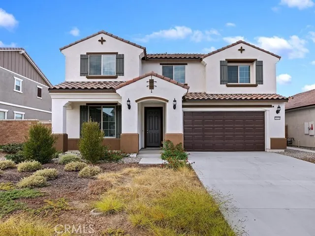 a front view of a house with yard and parking
