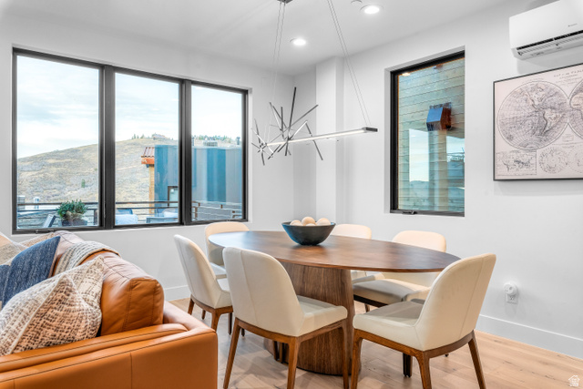 1258 Rothwell Road Park City, UT 84060 - Photo 11 of 48 Open concept living area featuring a contemporary oval dining table with seating for six, light wood-finish flooring, a linear chandelier, recessed lighting, and large windows with black framing