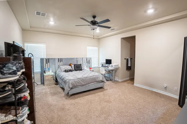 a spacious bedroom with a bed and a ceiling fan