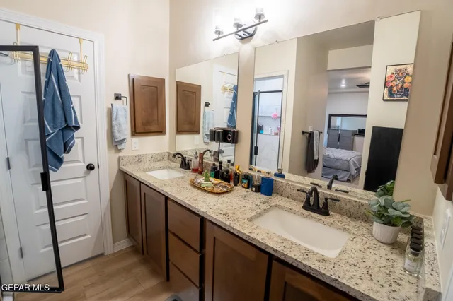 a bathroom with double vanity and a mirror