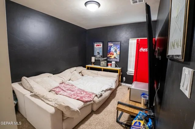 a bed room with a bed a flat screen tv and a window