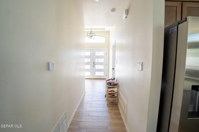 a view of a hallway with wooden floor and a bathroom