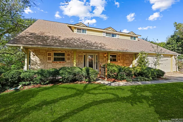 a front view of a house with a yard and outdoor seating
