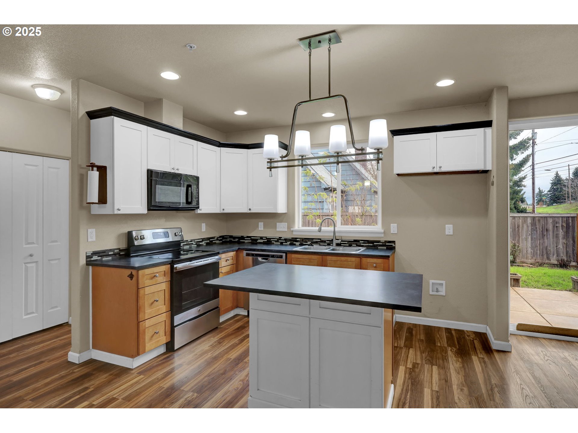 1725 Allea Drive Eugene, OR 97404 - Photo 11 of 44 a kitchen with kitchen island granite countertop stainless steel appliances and wooden floor