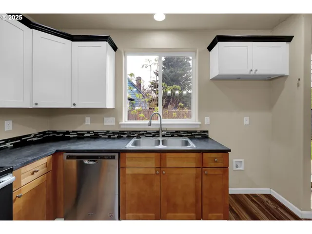 a kitchen with kitchen island granite countertop a sink window and cabinets