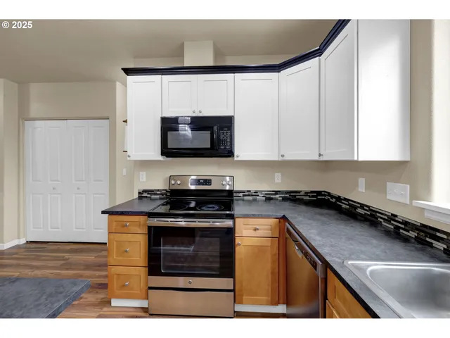 a kitchen with stainless steel appliances a stove a sink and a microwave