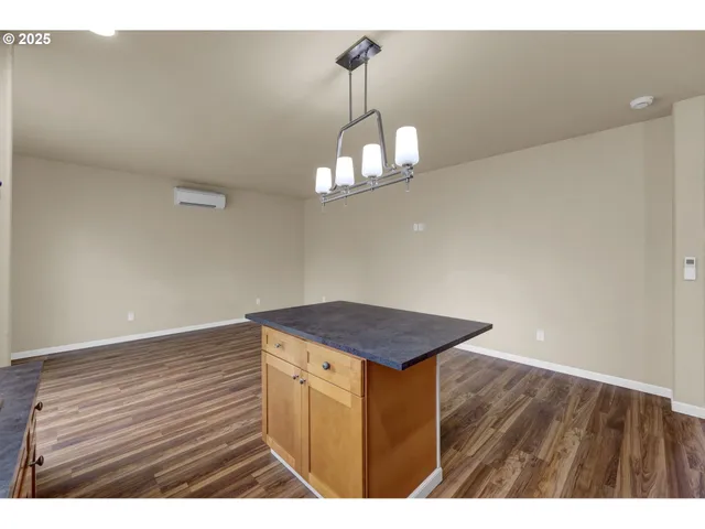 a kitchen view with wooden floor and a chandelier fan