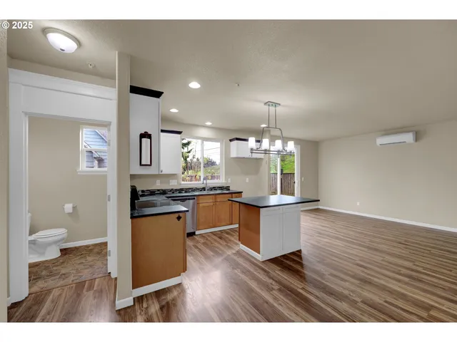 a open kitchen with a sink dishwasher a kitchen island a stove with wooden floor