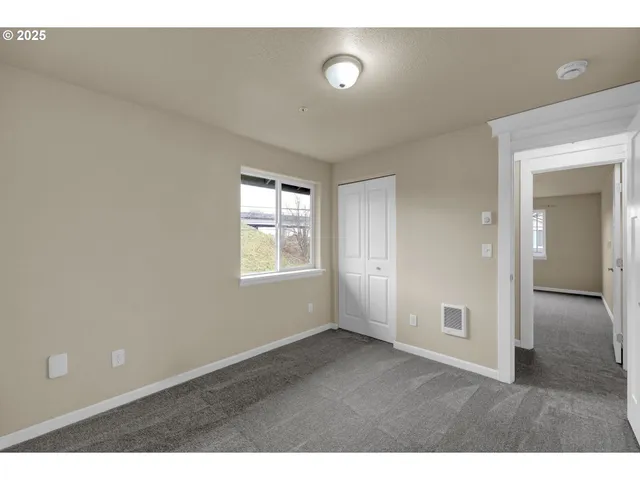 view of an empty room with closet and a window
