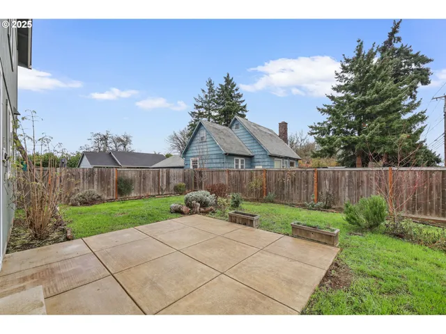 a view of a backyard with wooden fence
