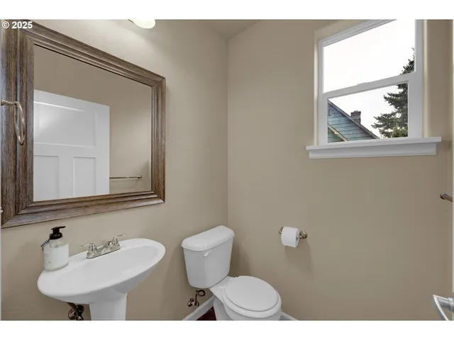 a bathroom with a toilet a sink and a mirror