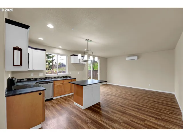 a kitchen with stainless steel appliances granite countertop a stove a sink dishwasher and a oven with cabinets