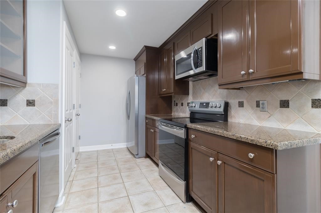 914 Main Street, Unit 1503 Houston, TX 77002 - Photo 4 of 33 a kitchen with stainless steel appliances granite countertop a sink and a stove