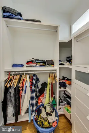a view of walk in closet with clothes and shoes