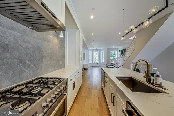 a kitchen with sink stove and cabinets