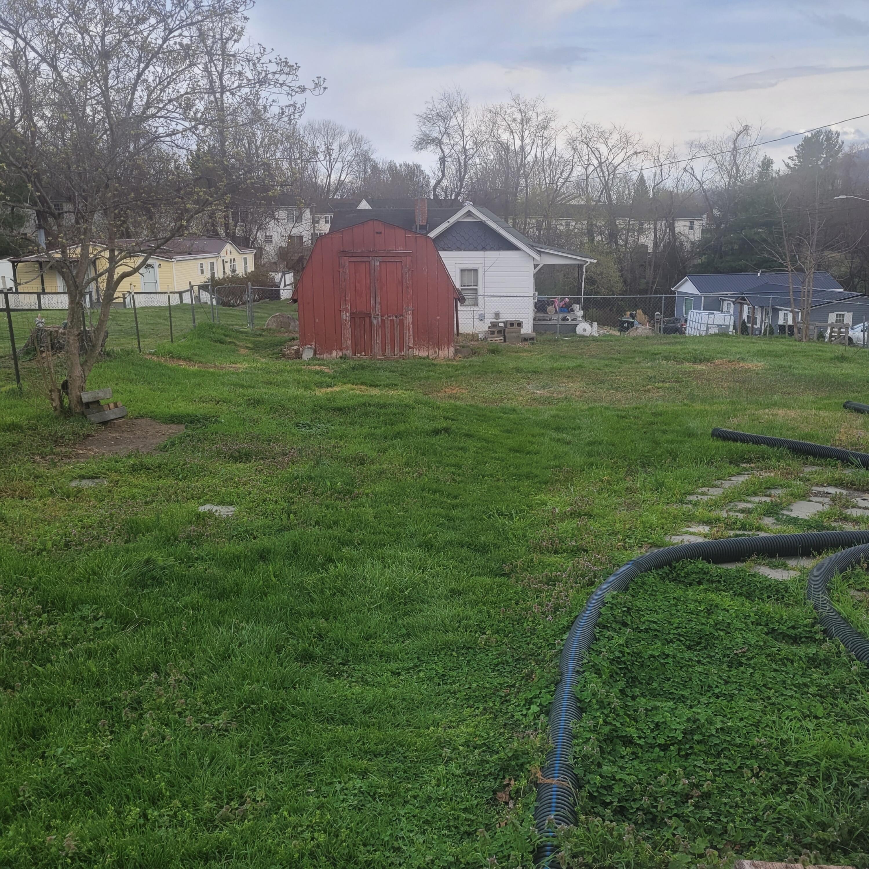 876 Dillon Street Pulaski, VA 24301 - Photo 4 of 18 a view of a big yard with a house in the background
