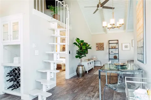 a living room with furniture a chandelier and wooden floor