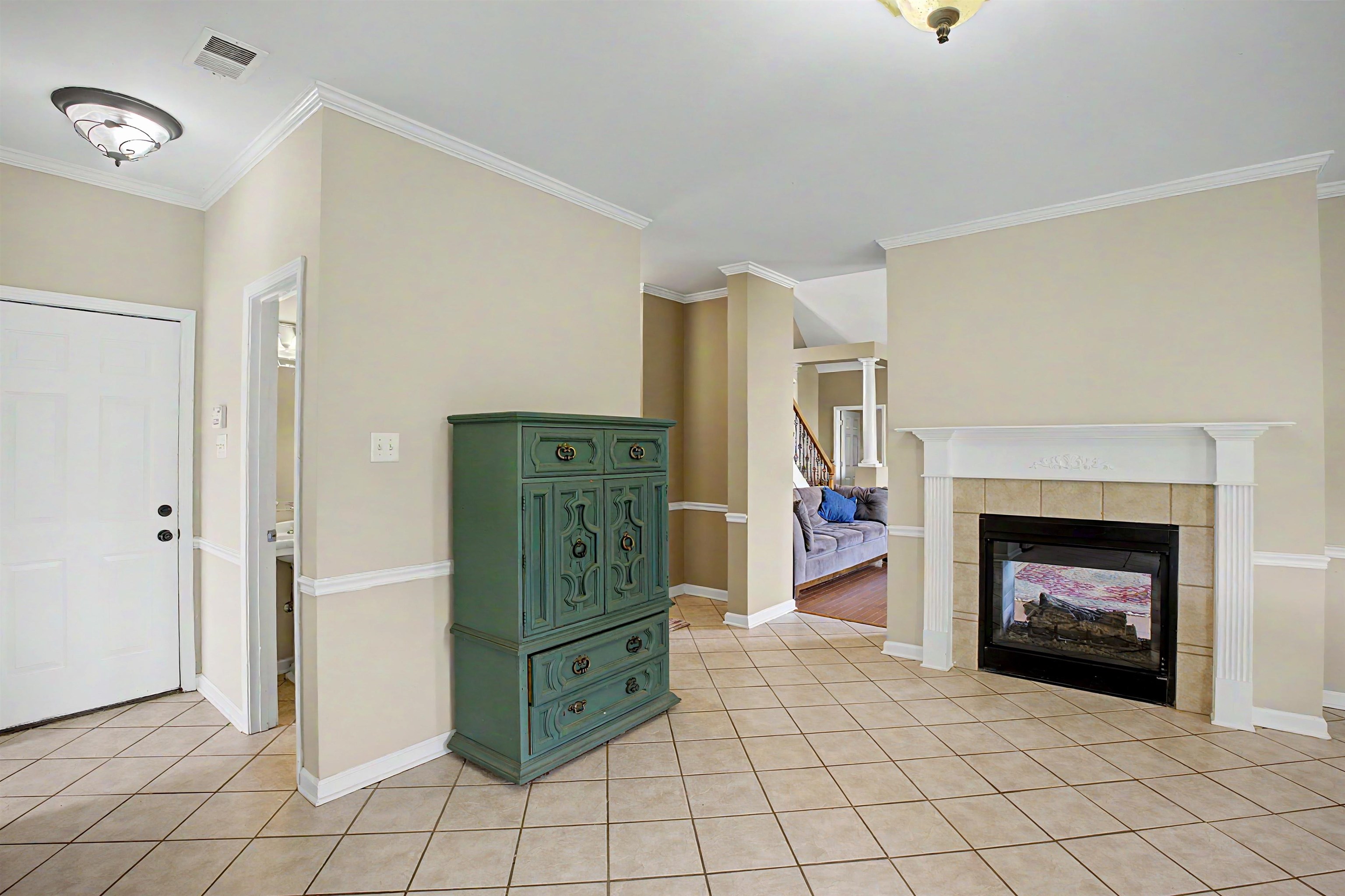 134 Rembert Drive Atoka, TN 38004 - Photo 21 of 38 Tiled flooring throughout the entry, fireplace with hearth and mantel, crown molding, chair rail molding, and paneled interior door