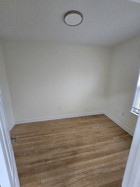 38 Fox Street, Unit 2 Worcester, MA 01604 - Photo 19 of 21 a view of an empty room with wooden floor and fan