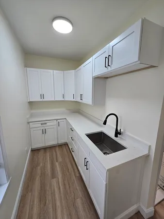 a kitchen with a sink a stove and cabinets