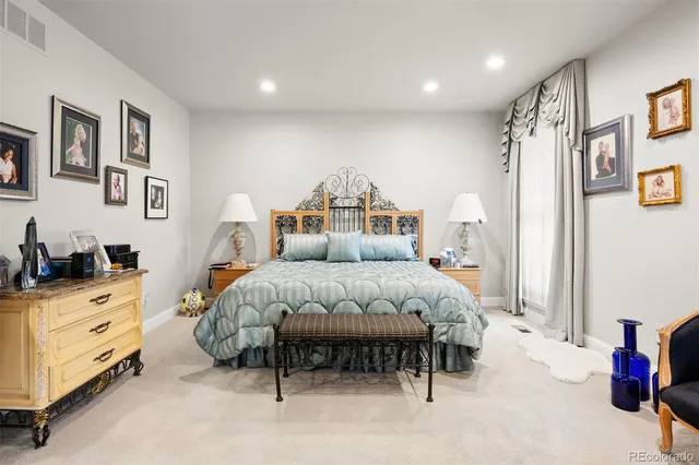 a spacious bedroom with a bed and a cabinets