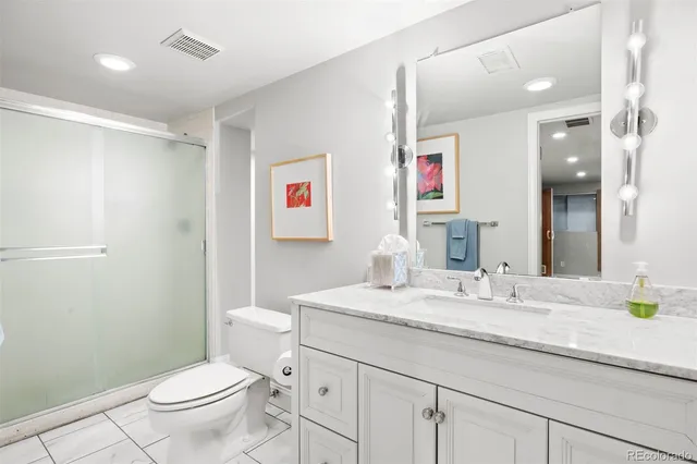a bathroom with a granite countertop sink a toilet and a mirror