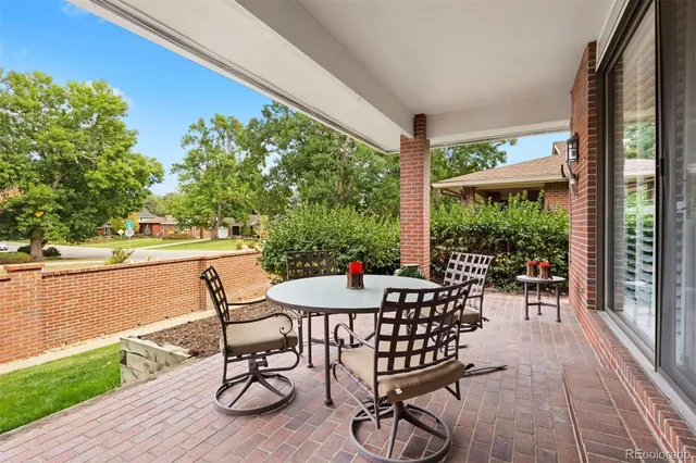 a view of a patio with table and chairs and wooden floor