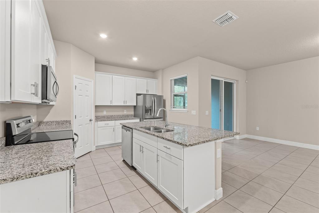 2224 Shadowland Loop Winter Park, FL 32792 - Photo 11 of 42 a kitchen with stainless steel appliances granite countertop a sink stove and cabinets