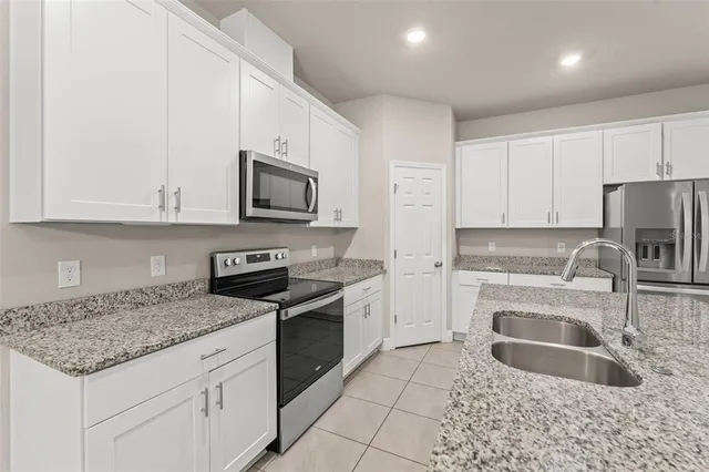 a bathroom with a granite countertop sink a mirror and a shower