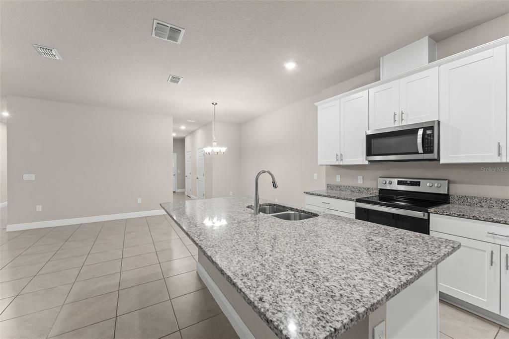 2224 Shadowland Loop Winter Park, FL 32792 - Photo 14 of 42 a kitchen with granite countertop a sink a counter top space appliances and cabinets