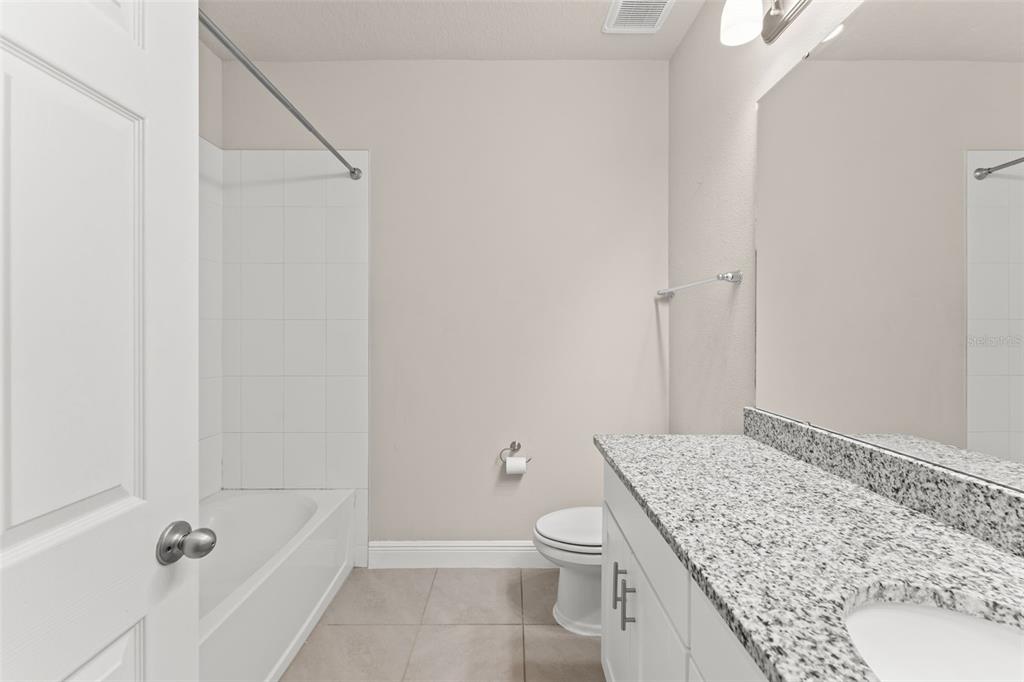 2224 Shadowland Loop Winter Park, FL 32792 - Photo 33 of 42 a bathroom with a granite countertop sink a toilet and shower