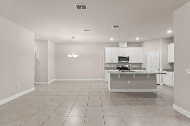 a kitchen with granite countertop a sink a counter top space appliances and cabinets