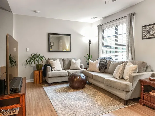 a living room with furniture a flat screen tv and a window