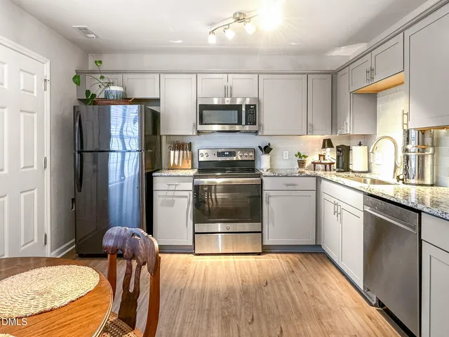 a kitchen with granite countertop a refrigerator stove and sink