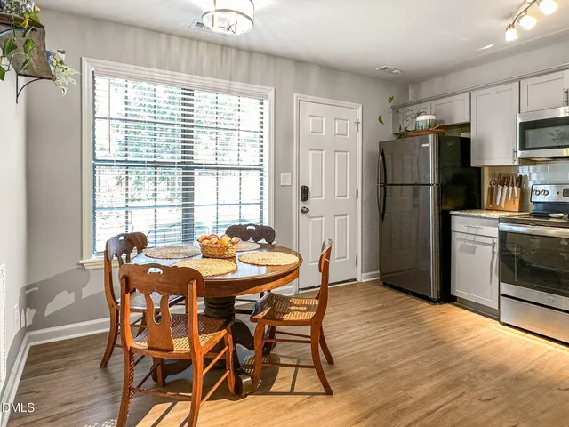 a dining room with furniture a window and stainless steel appliances