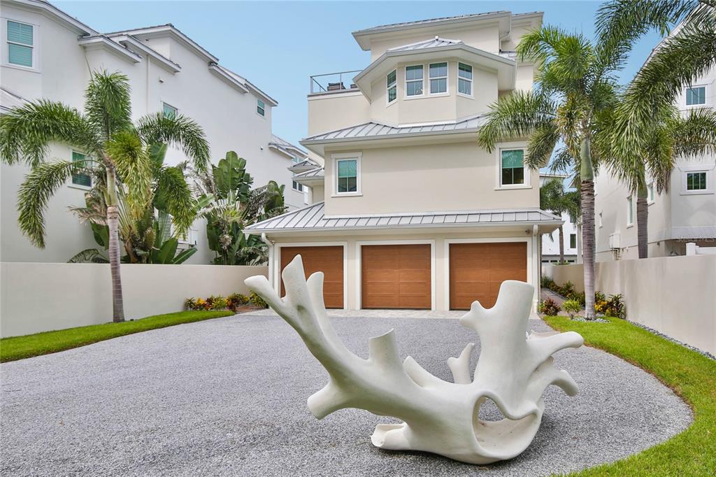 a view of a white house with a big yard and potted plants