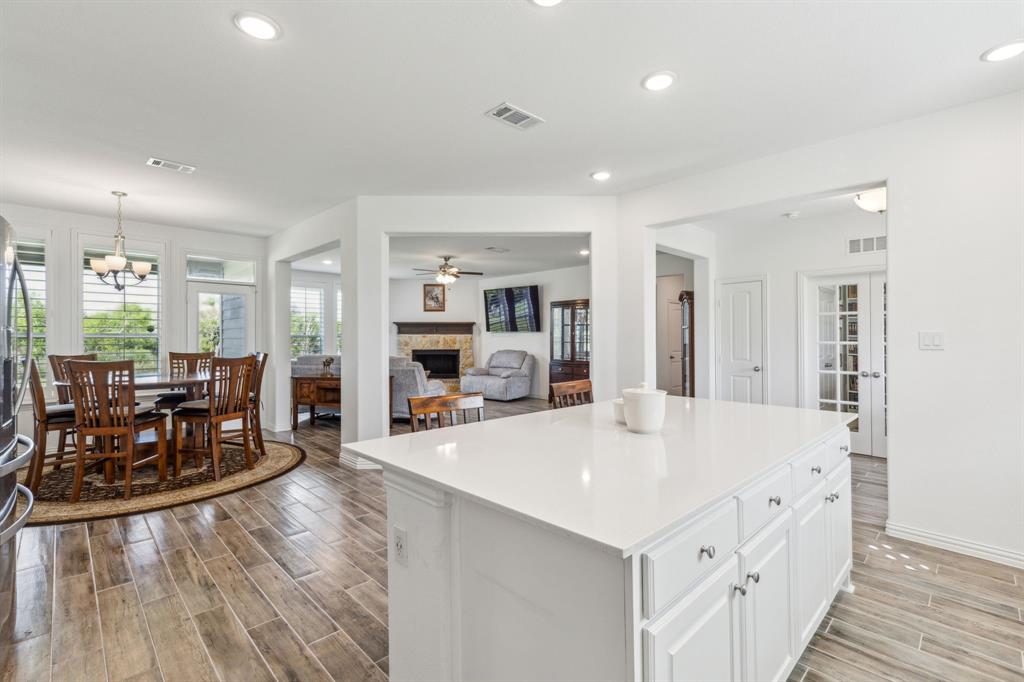 2410 Black Jack Oak Road Terrell, TX 75161 - Photo 13 of 31 Kitchen with a stone fireplace, light wood-style floors, white cabinetry, a center island, and recessed lighting
