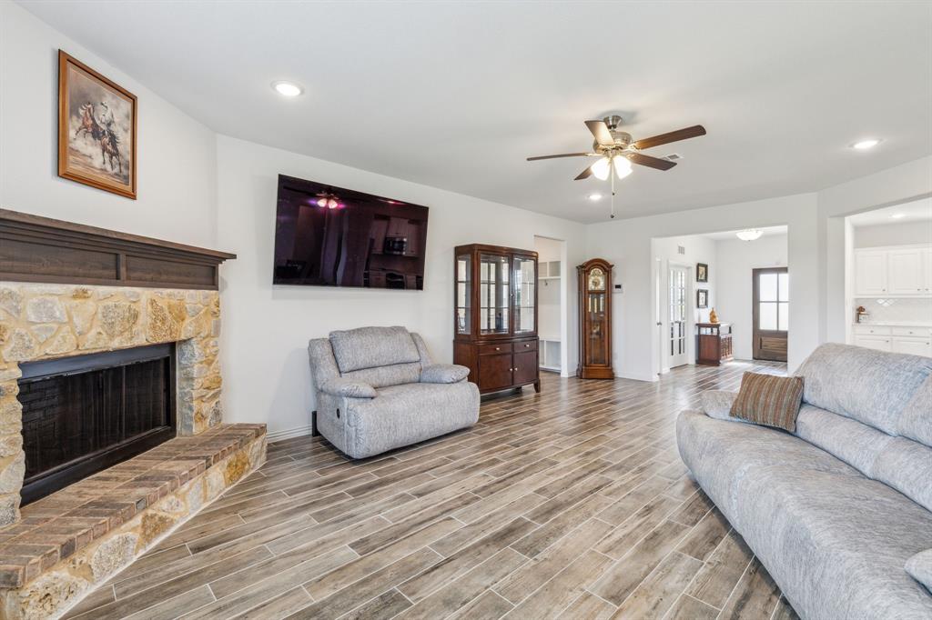 2410 Black Jack Oak Road Terrell, TX 75161 - Photo 18 of 31 Living area with a ceiling fan, light wood-style flooring, baseboards, a stone fireplace, and recessed lighting