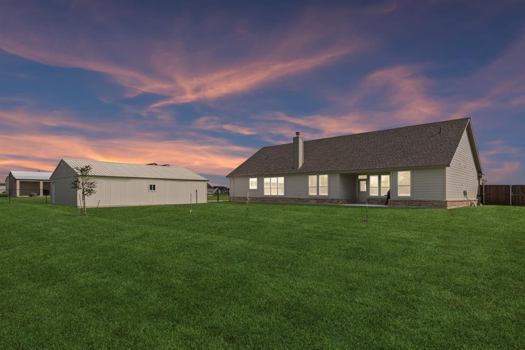 2410 Black Jack Oak Road Terrell, TX 75161 - Photo 2 of 31 Rear view of house with a yard, a chimney, roof with shingles, and an outbuilding